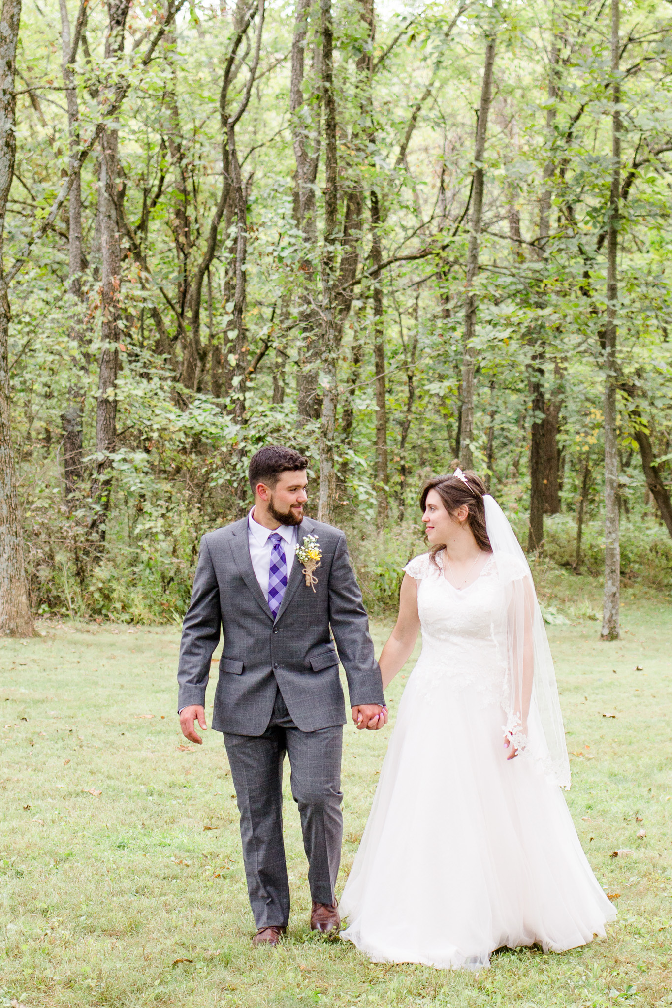 Beaded blush wedding dress and groom with gray suit
