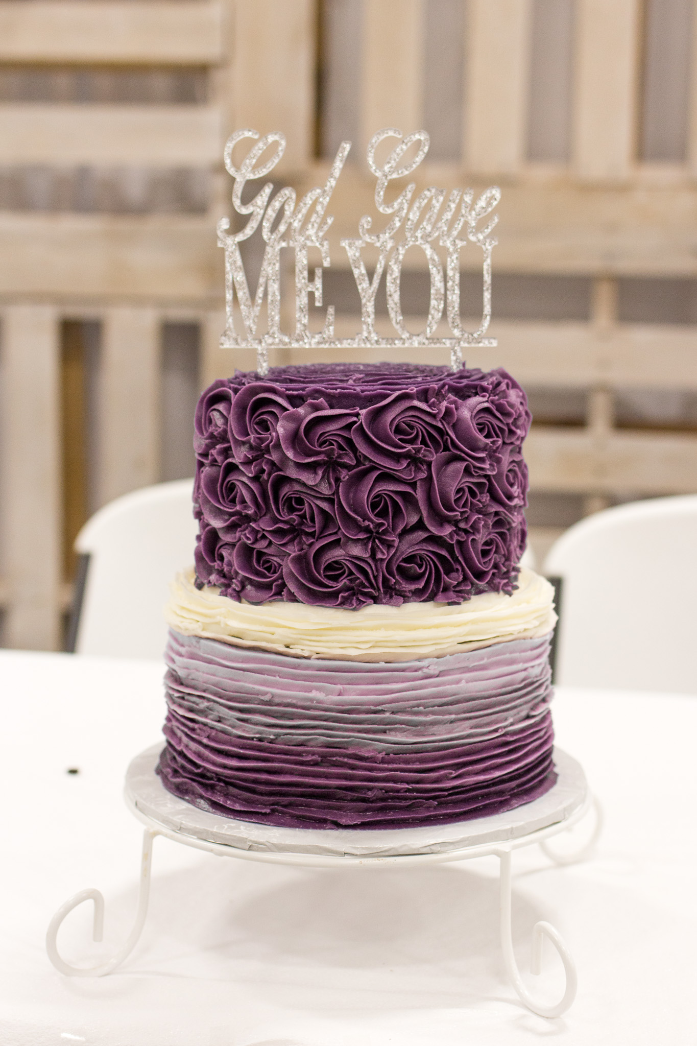 Purple wedding cake with icing flowers and ruffles