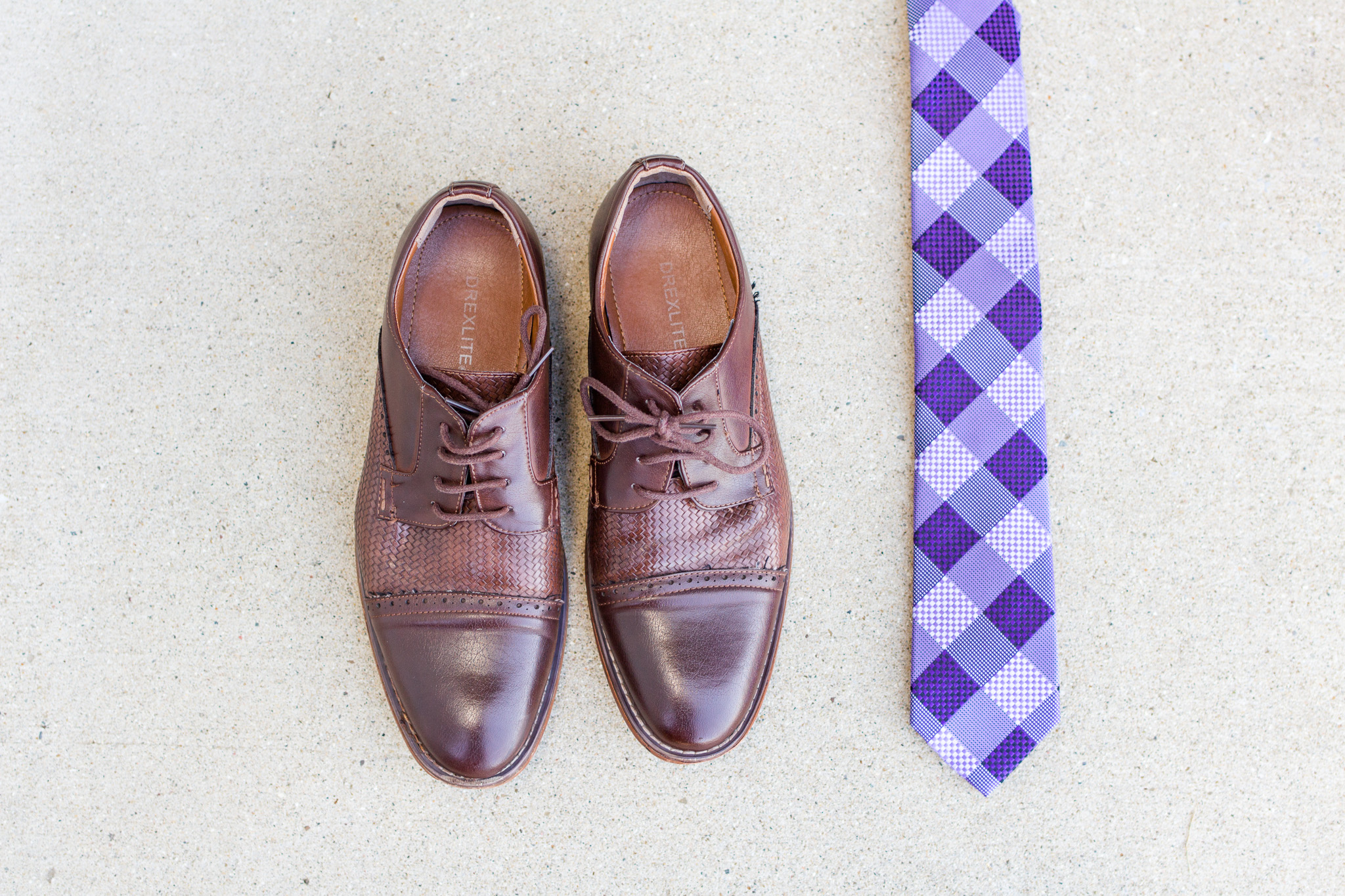 Dark brown groom's wedding shoes and purple tie