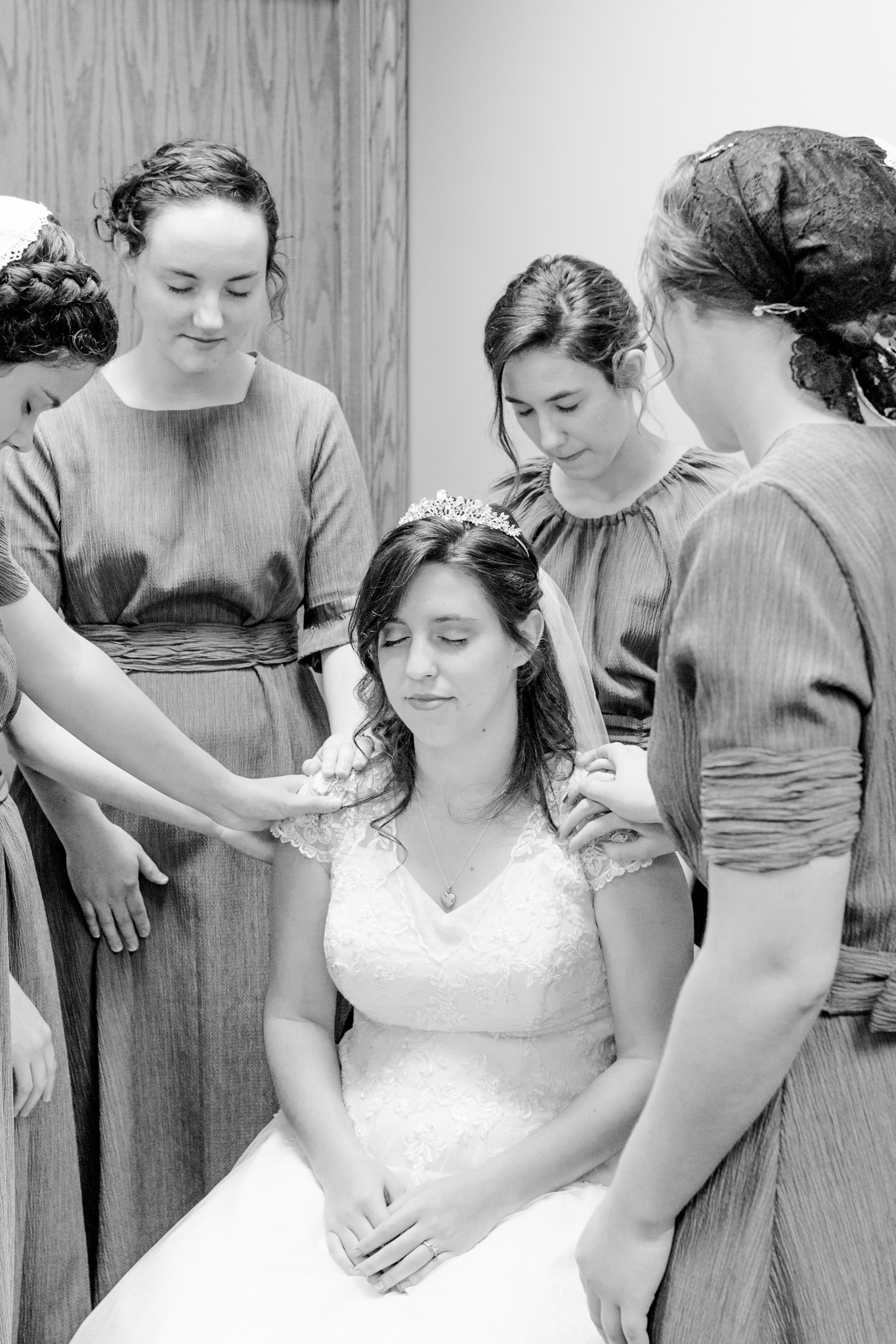 Bridesmaid praying with bride