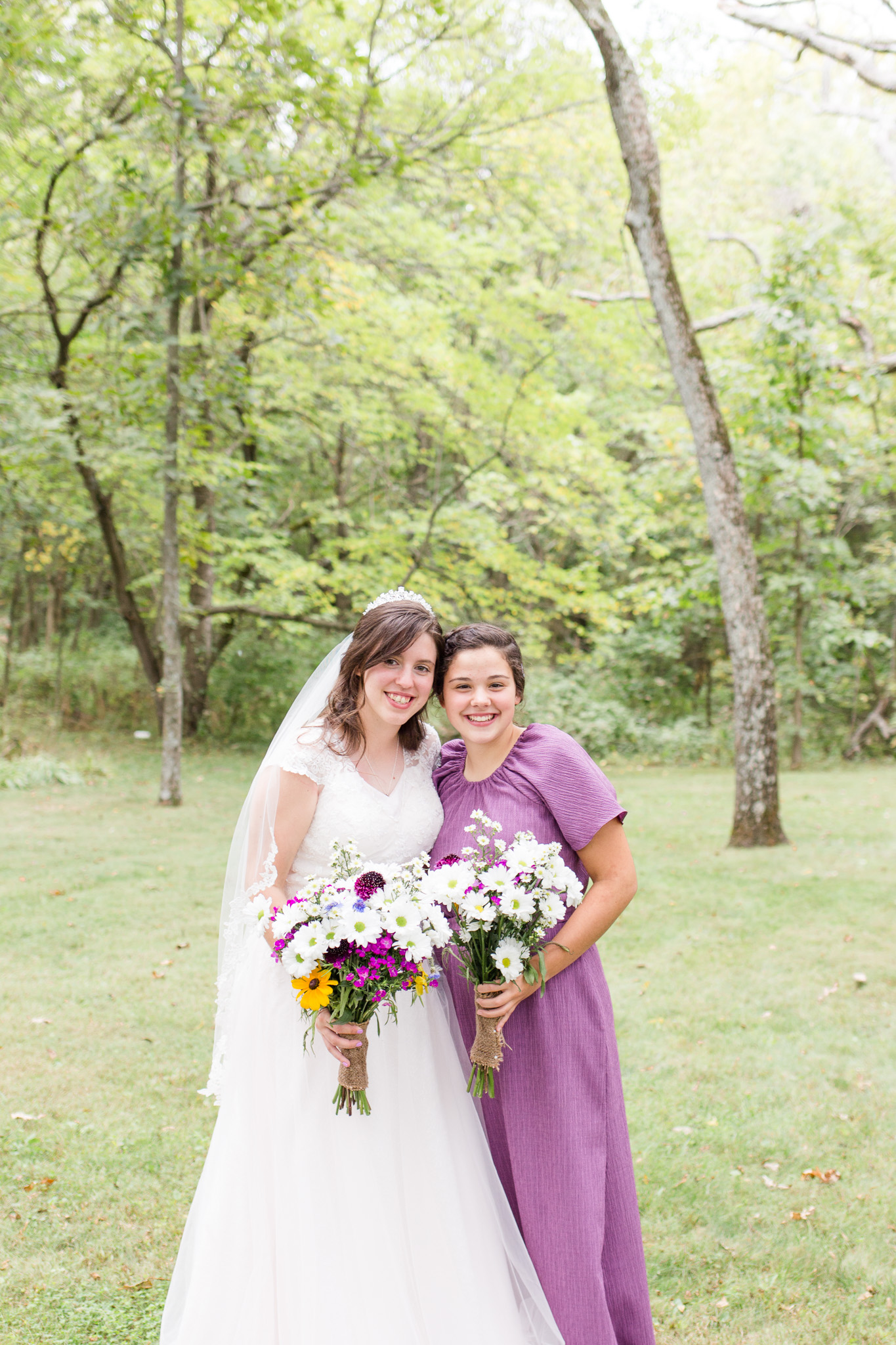 Beaded lace blush bride's wedding dress and purple bridesmaid dress