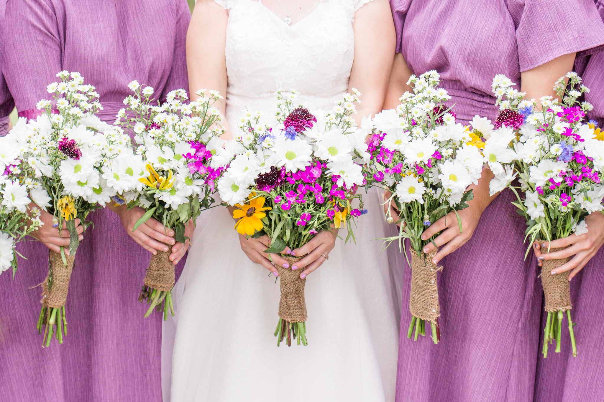 Purple bridesmaid dresses and wildflower wedding bouquet